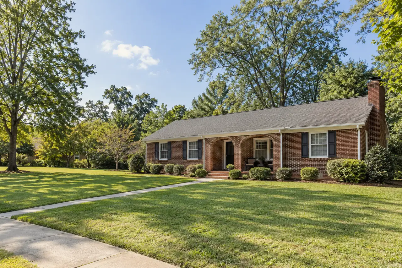 Illustrative scene: a 1950s red-brick ranch house with an arched front porch and a neat lawn in Greensboro, North Carolina